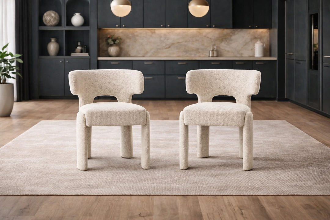 Two beige chairs in a modern kitchen setting with dark cabinets and a light-colored rug.