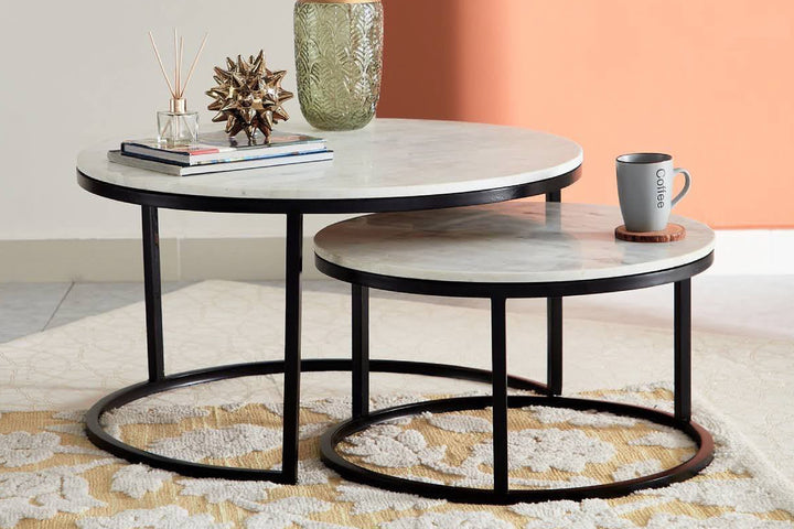 Two-tier coffee table with decorative items against a colorful background