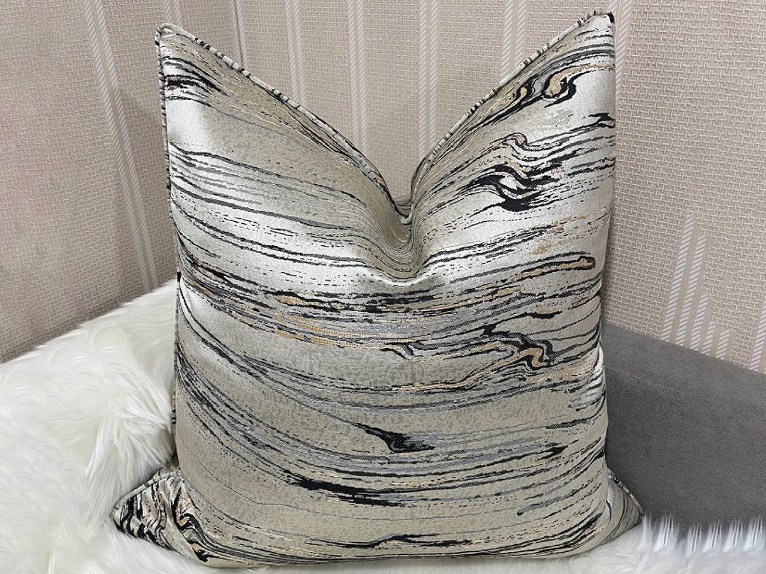 Decorative pillow with black and white abstract pattern on a neutral background