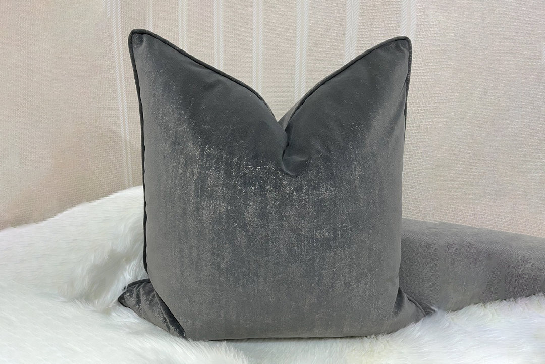 Gray pillow on a bed with a neutral background