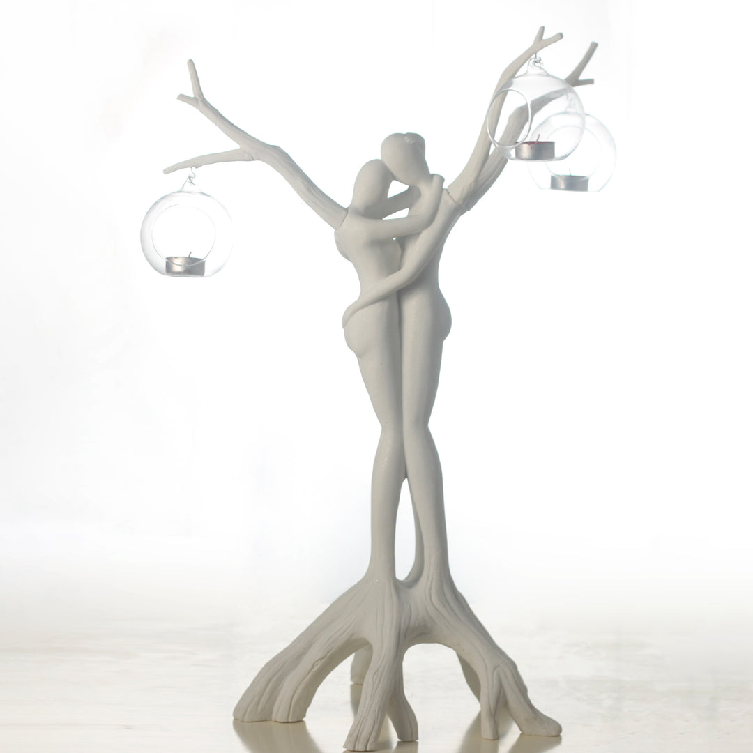 Decorative sculpture of two figures intertwined with branches on a white background
