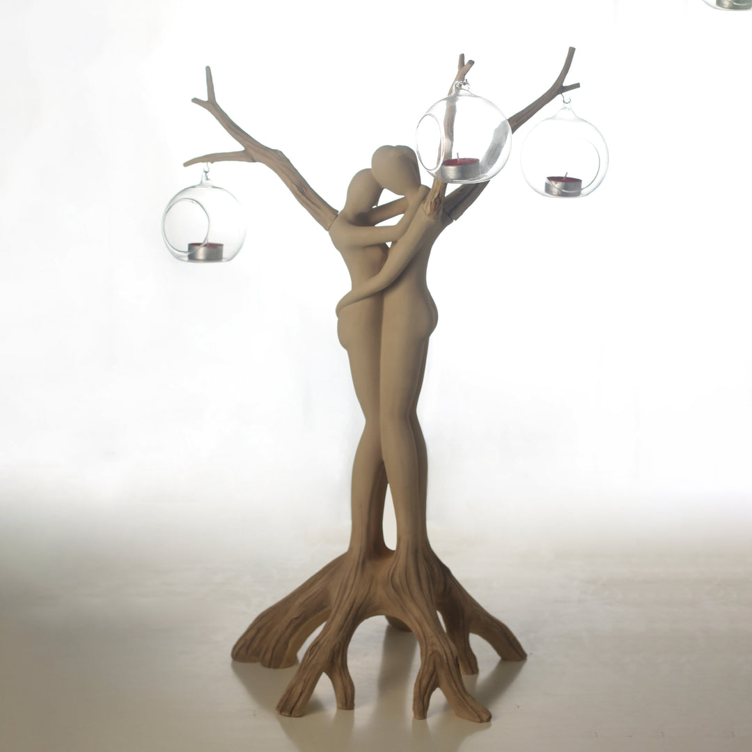 Decorative candle holder shaped like a couple embracing with branches, on a white background.