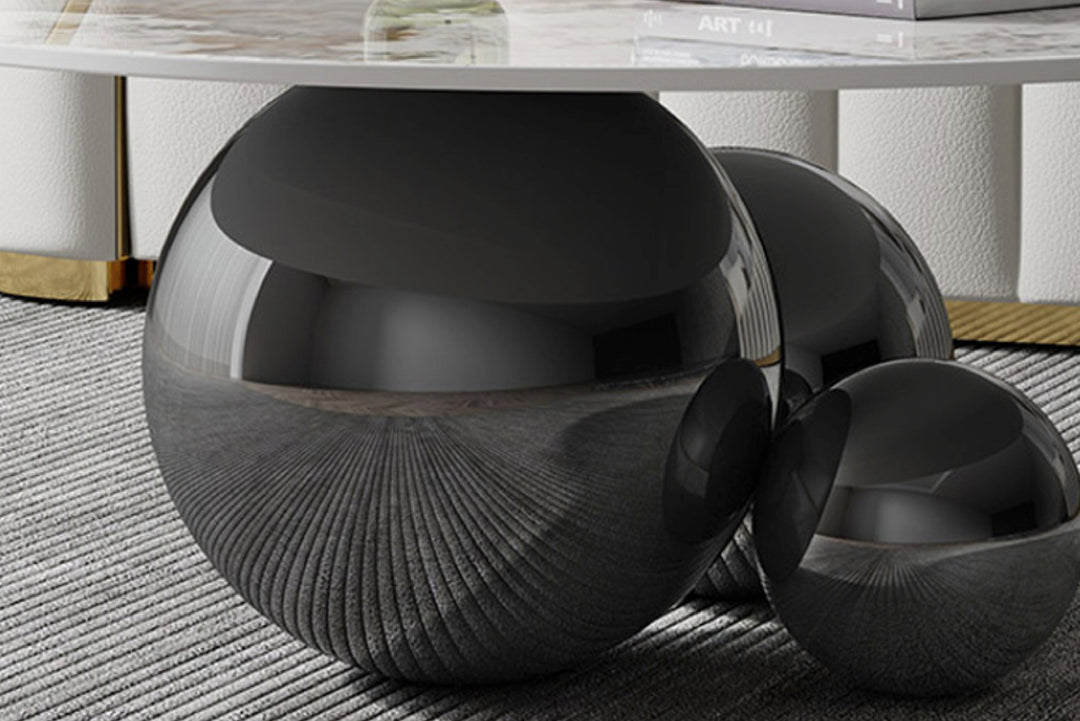 Black textured coffee table with a marble top on a textured floor.