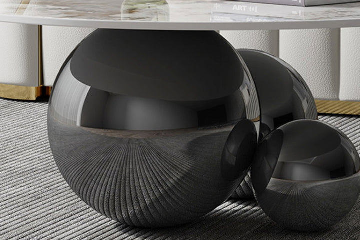 Black textured coffee table with a marble top on a textured floor.