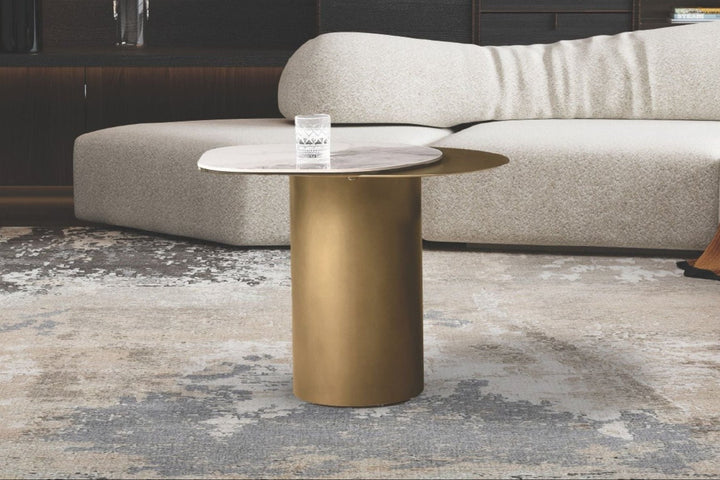 Modern living room with a white sofa, gold coffee table, and abstract rug.