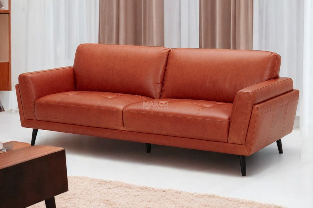 Orange sofa in a room with curtains and a rug