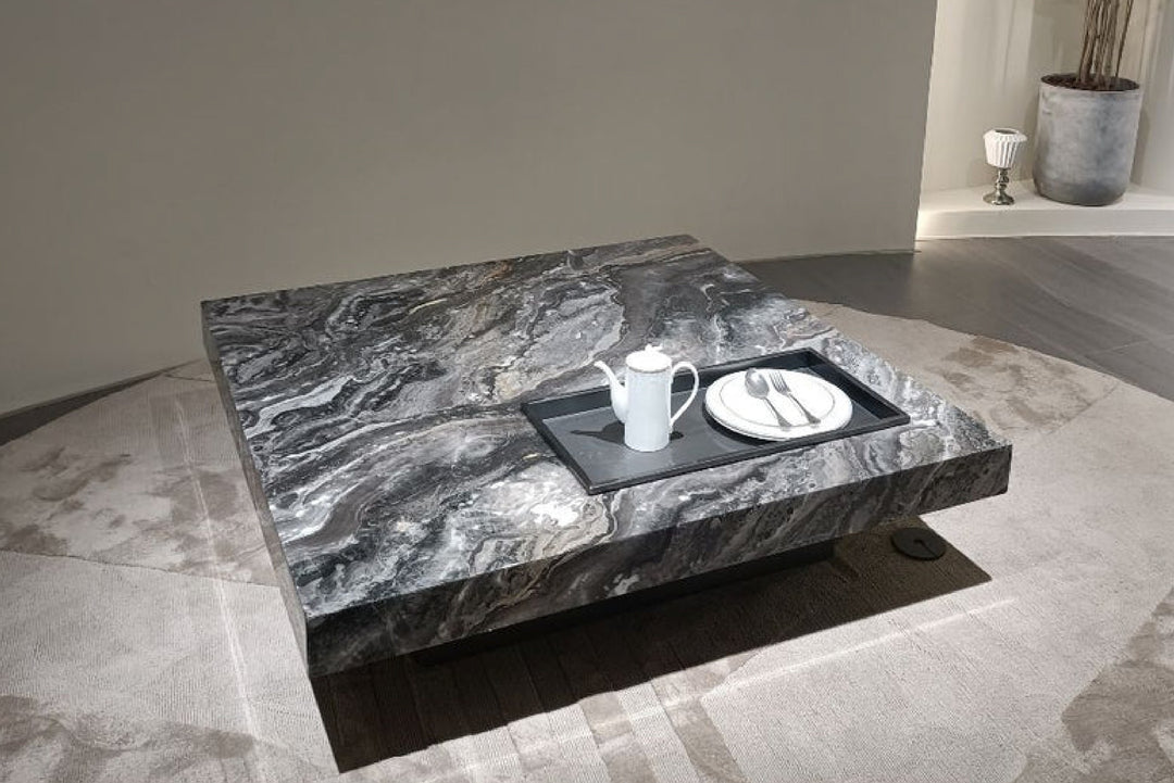 Marble coffee table with a teapot and plate in a modern room.