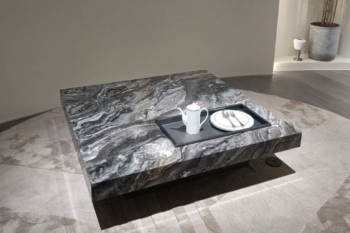 Marble coffee table with a teapot and plate in a modern room.