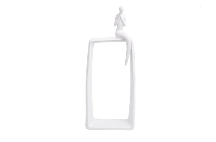 White ceramic abstract art statue featuring a human figure sitting atop a vertical hollow rectangle base.