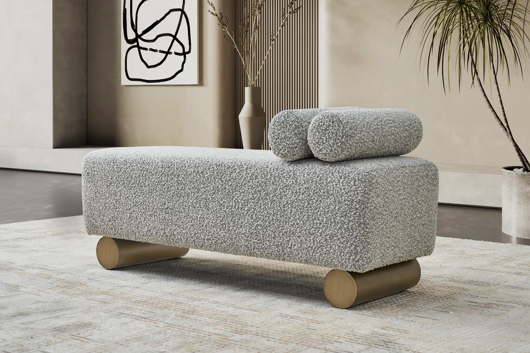 Gray textured ottoman with wooden legs in a modern living room setting.