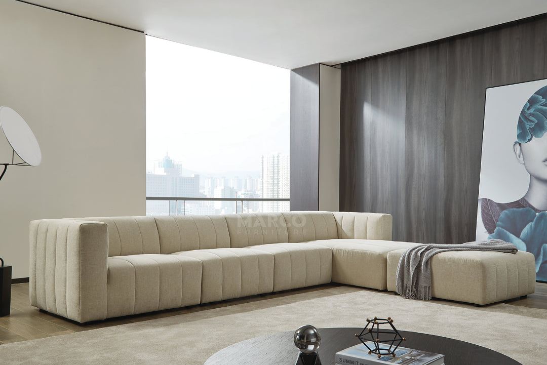 Modern living room with a beige sectional sofa, coffee table, and large window.