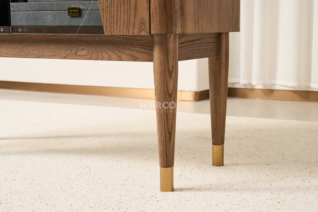Wooden cabinet with gold feet on a light carpet