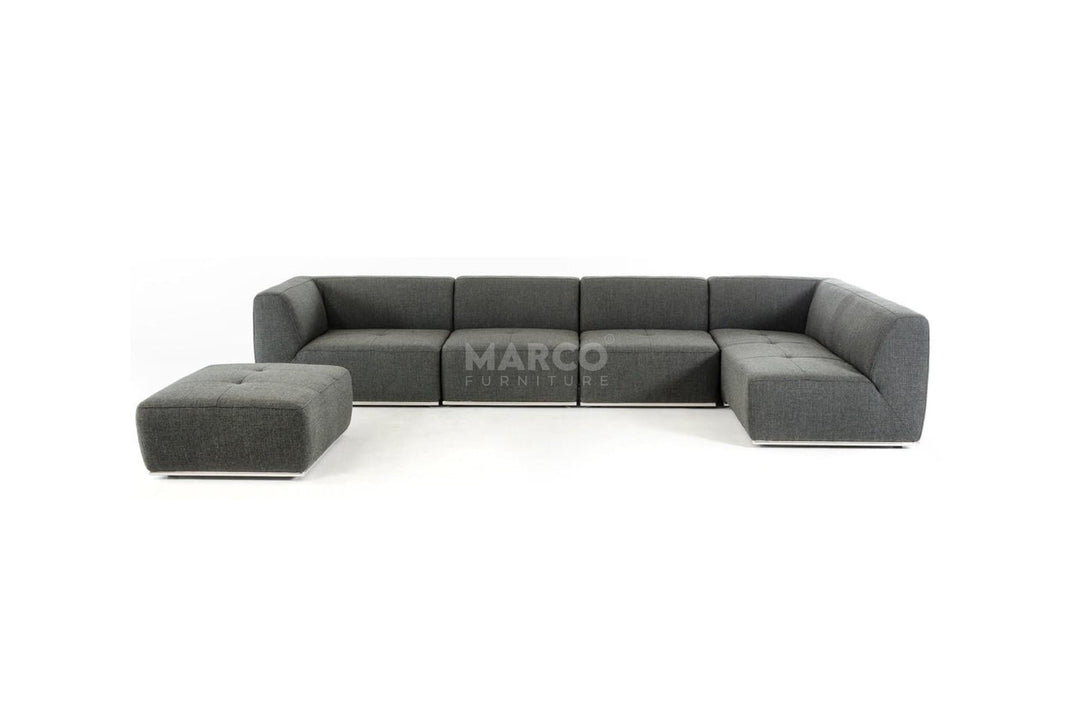 Gray sectional sofa with ottoman on a white background, featuring the brand 'Marco'.