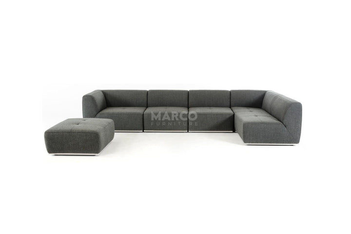 Gray sectional sofa with ottoman on a white background, featuring the brand 'Marco'.
