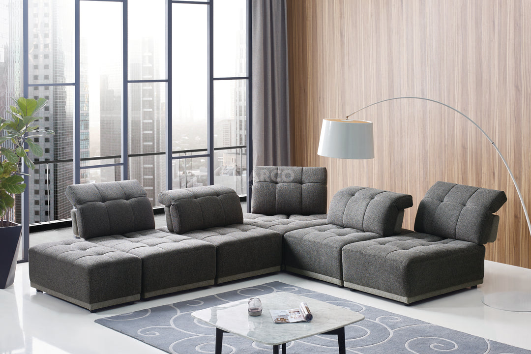 Modern living room with a gray sectional sofa, coffee table, and decorative elements.