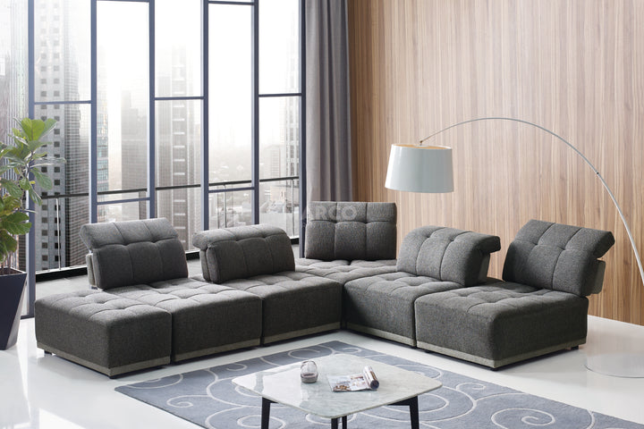 Modern living room with a gray sectional sofa, coffee table, and decorative elements.