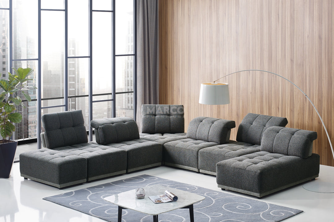 Modern living room with a gray sectional sofa, coffee table, and decorative items.