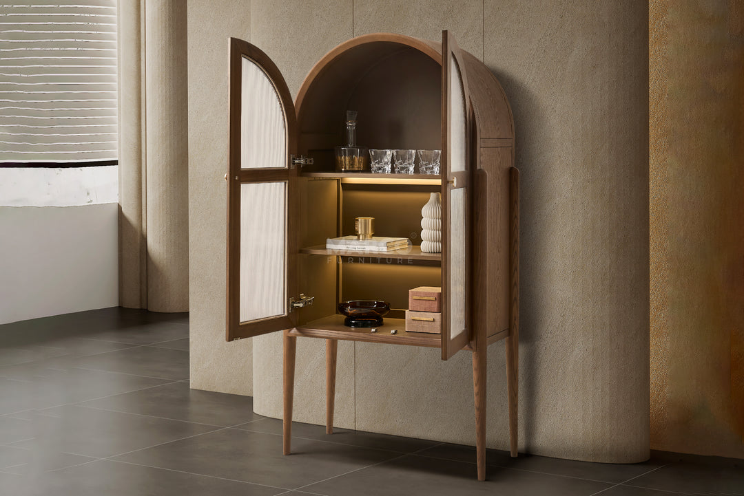 Wooden cabinet with open doors displaying decorative items against a neutral wall.