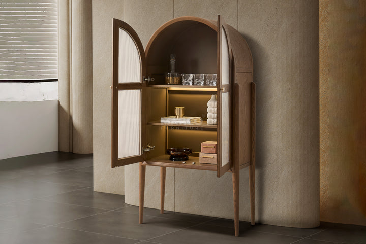 Wooden cabinet with open doors displaying decorative items against a neutral wall.