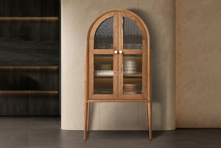 Wooden display cabinet with glass doors against a beige wall.