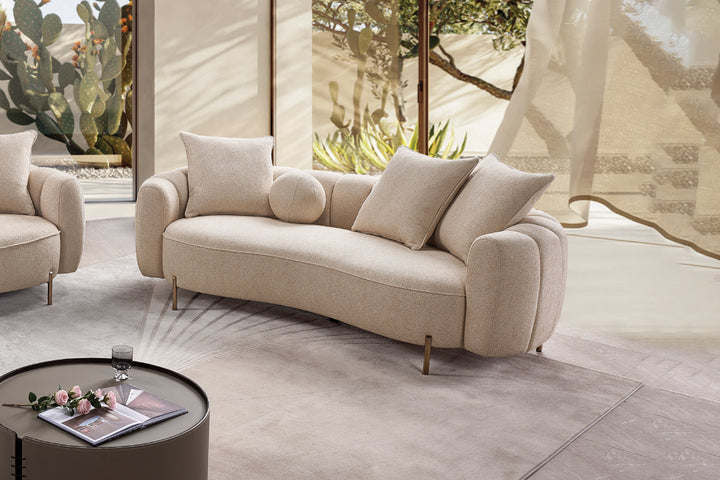 Beige sofa in a modern living room with a small round table and decorative items.
