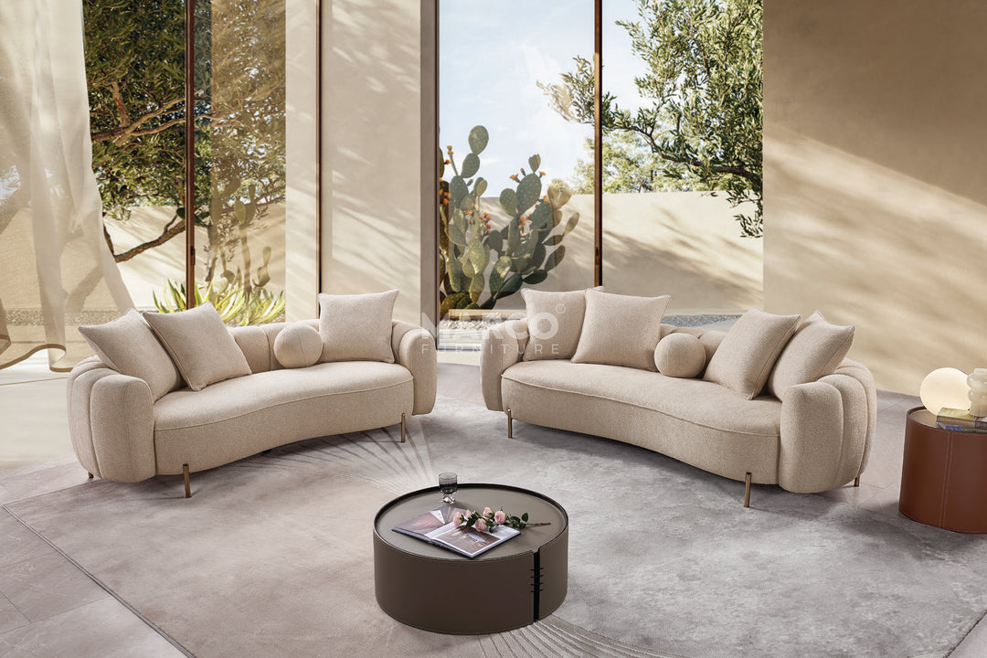 Modern living room with beige sofas and a round coffee table.