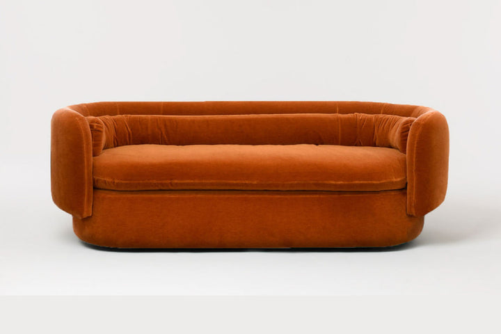 Orange velvet sofa on a white background