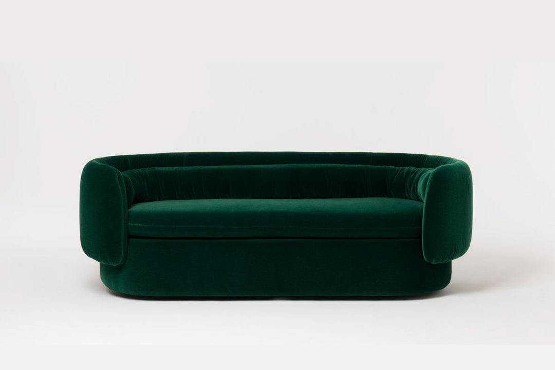 Green velvet sofa on a white background
