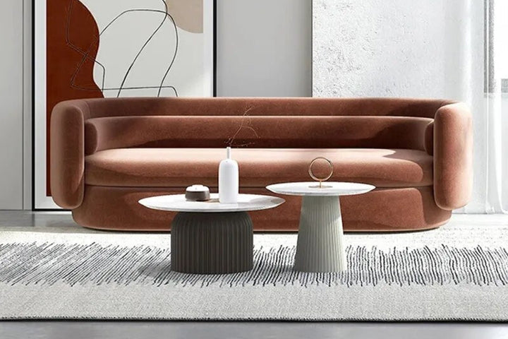 Modern living room with a brown sofa, coffee table, and decorative items.