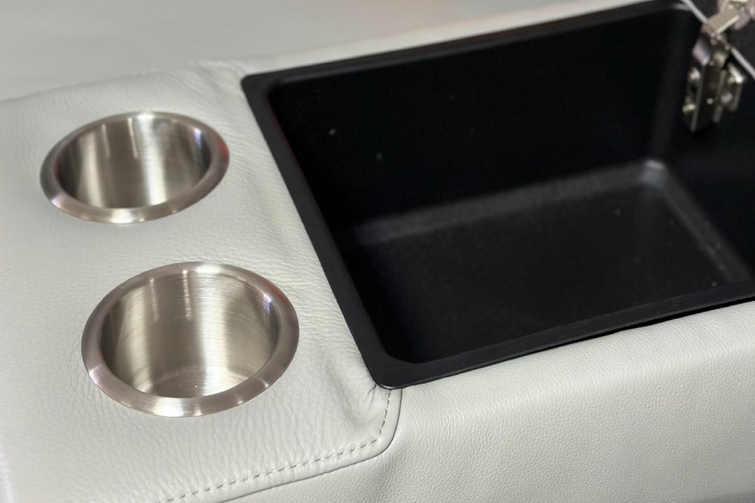 Car cup holder with two silver drink holders and a black tray on a white interior background.
