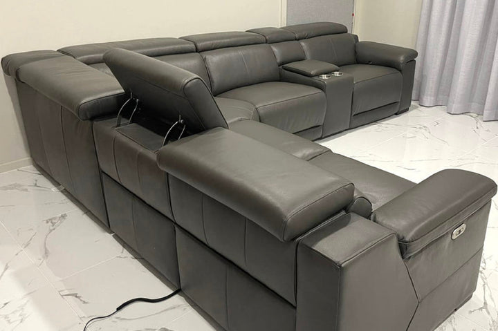 Gray sectional sofa with reclining seats on a marble floor.