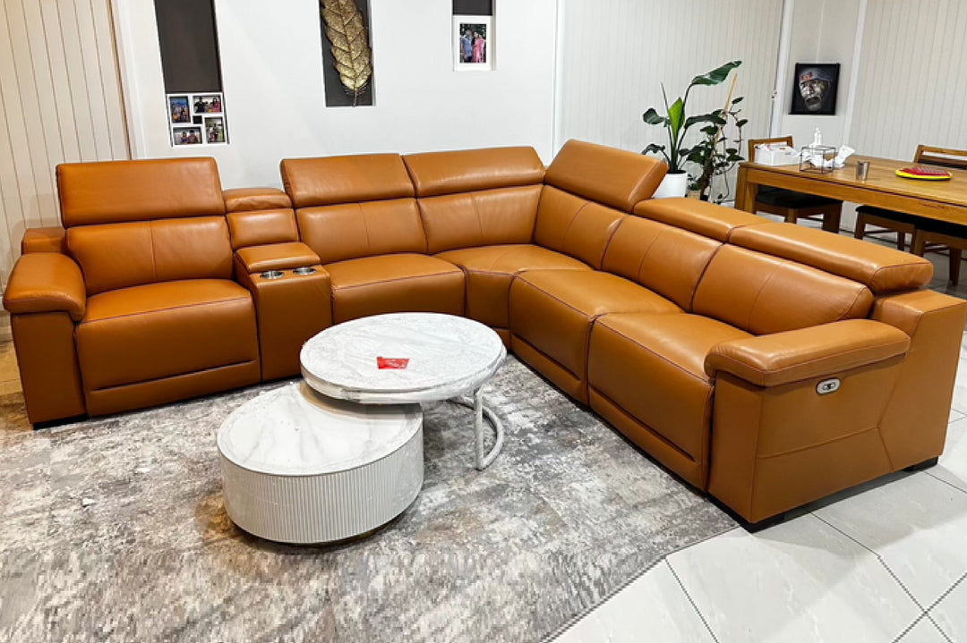 Brown leather sectional sofa in a living room setting with a coffee table.