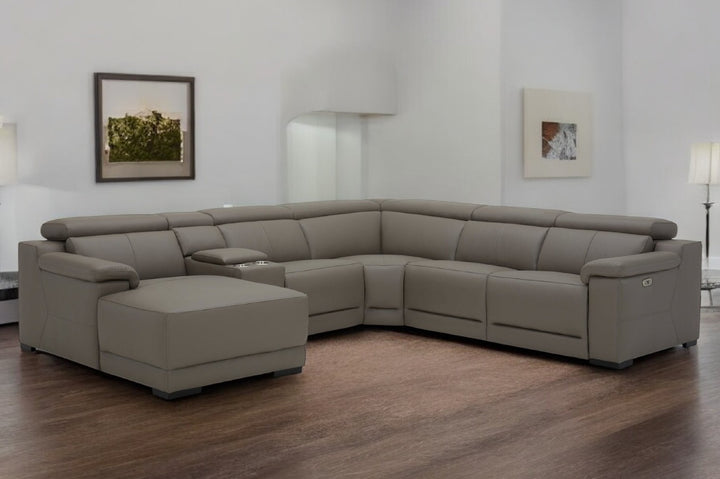 Gray sectional sofa in a room with wooden flooring and white walls.